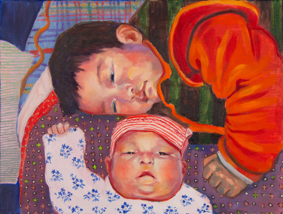 Two babies resting together amid colorful patterned blankets.